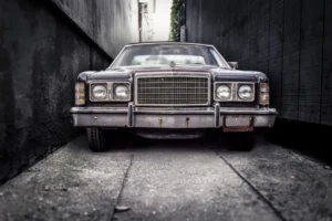 A classic American car, parked in a cramped alley, showcases the timeless design of vintage automobiles.