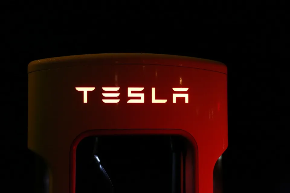 a red Tesla sign with text on it
