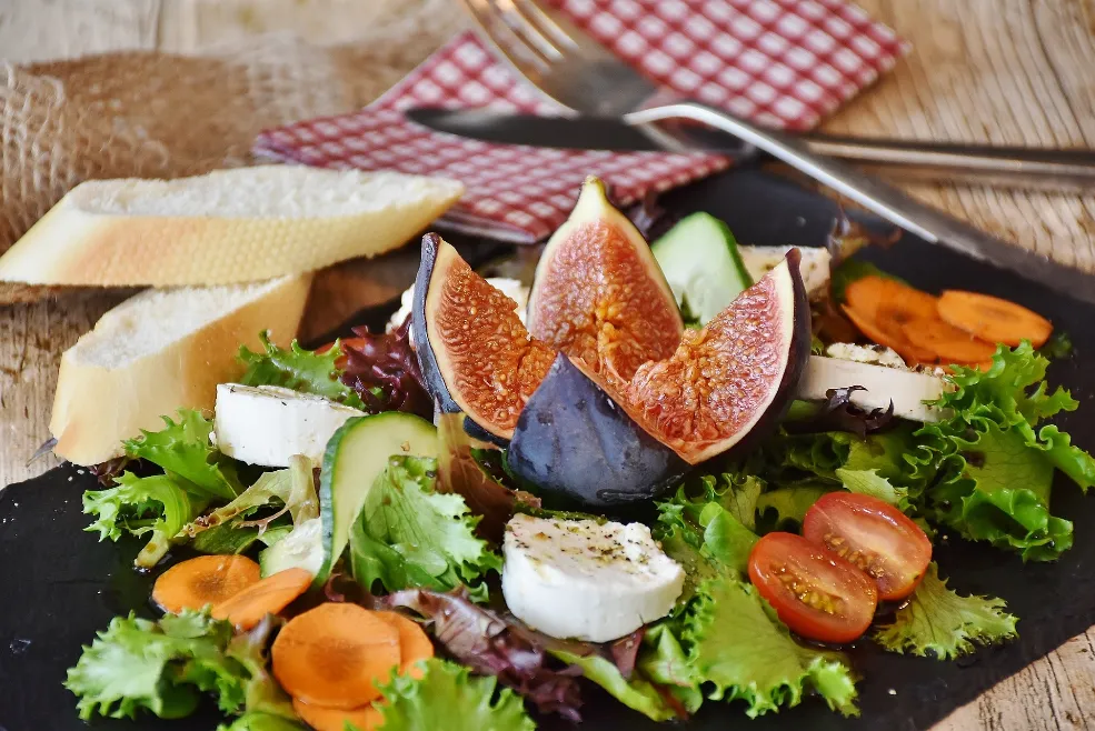 A plate of salad featuring figs, carrots, and cheese, accompanied by additional tips for dietary tweaks.