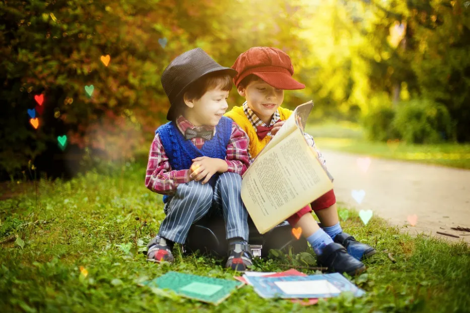 Two boys reading books on a park bench, improving their language skills as part of their education.