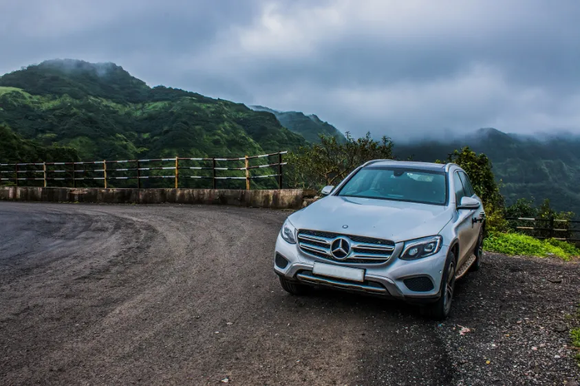 A silver Mercedes SUV parked on a mountain road, showcasing its Performance Conquering All Terrains.