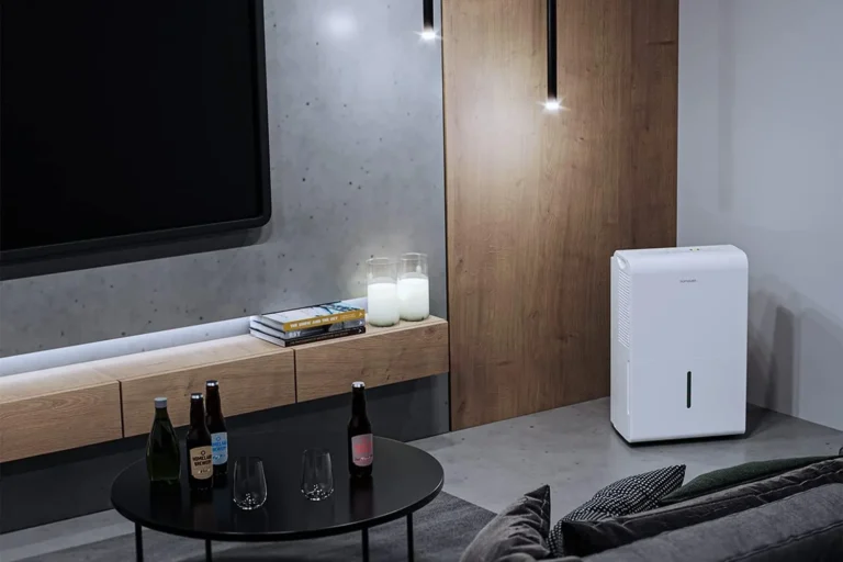 A cozy living room featuring a TV, couch, and refrigerator. Enhance comfort with Portable Home Dehumidifiers.