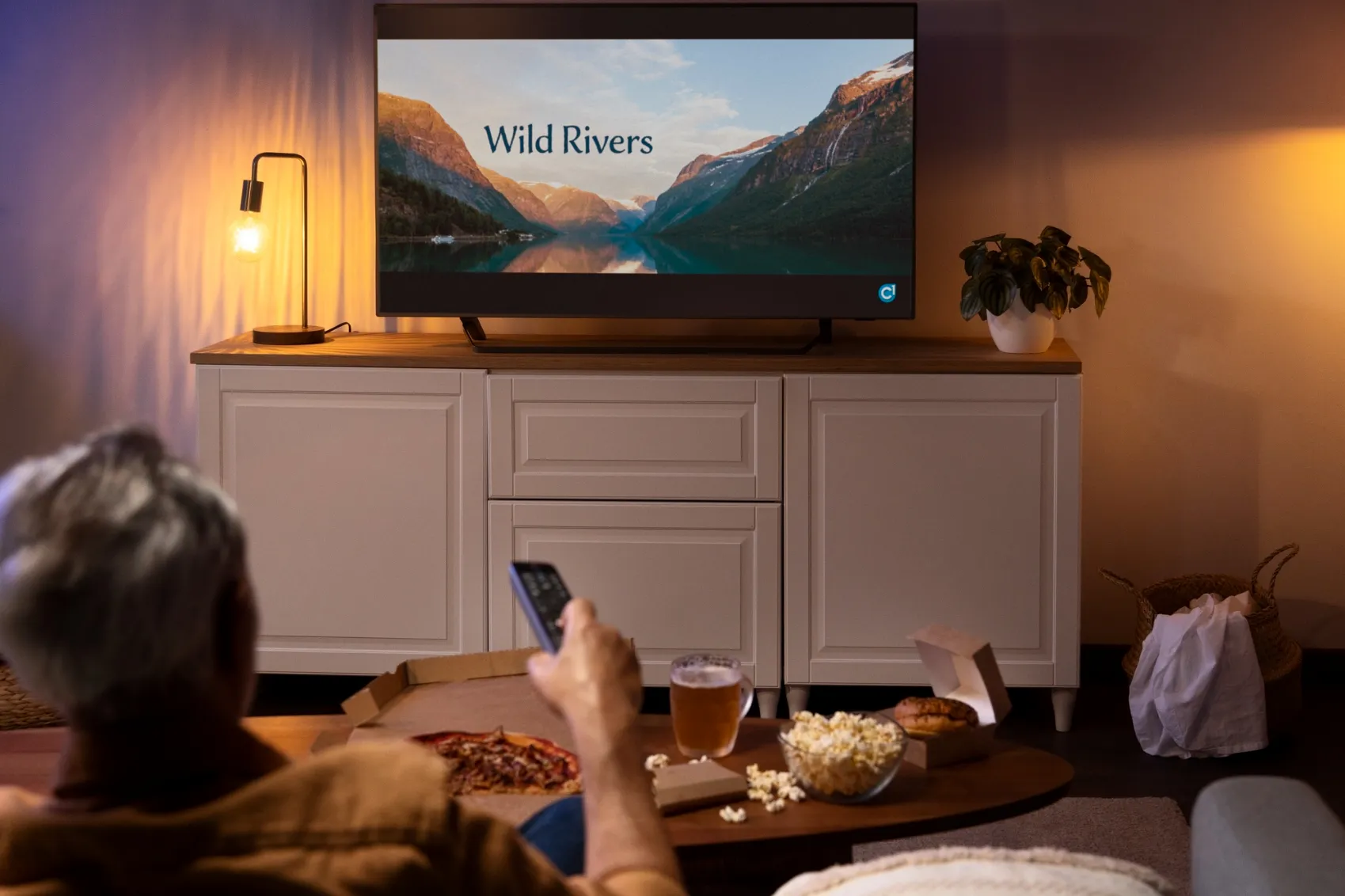 A man enjoys a Smart TV, embracing the benefits of modern tech.