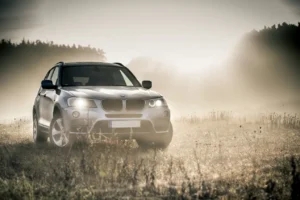 SUV drives through a field at sunrise, proving its all-purpose capabilities.