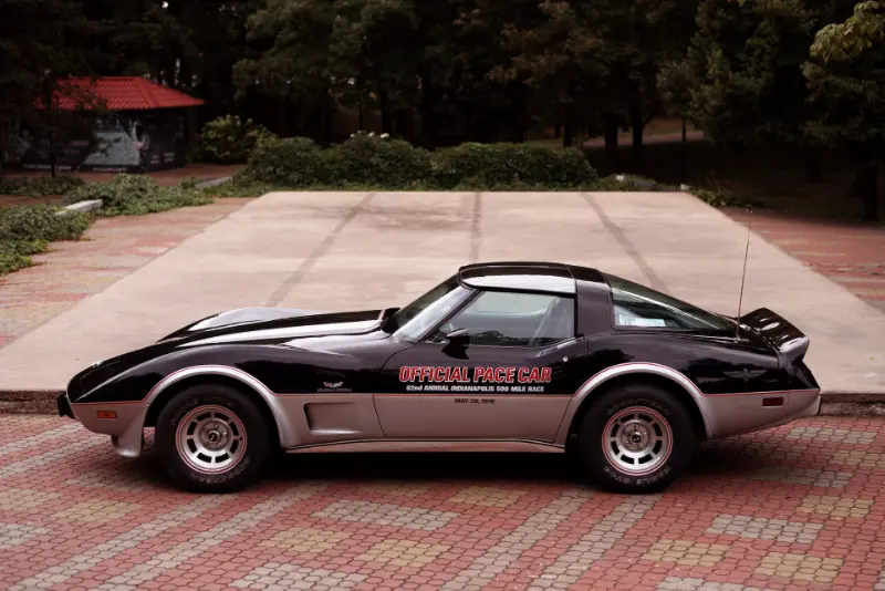 A sleek black and silver Corvette parked on a brick road, exuding elegance and power.