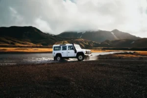 Land Rover Defender driving through Icelandic terrain.