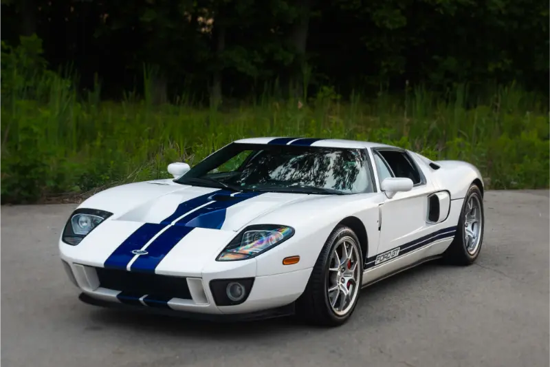 White and blue Ford GT parked on road.