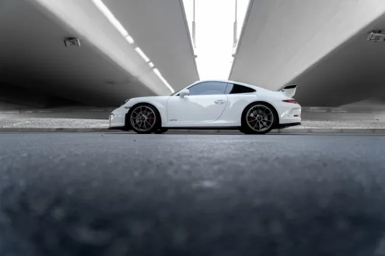 A white Porsche 911, a sleek sports car, parked in an underground tunnel, exuding elegance and power.