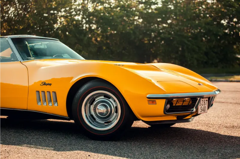A parked yellow Corvette car on the road.