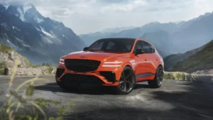 Luxury orange SUV parked on a scenic mountain road.